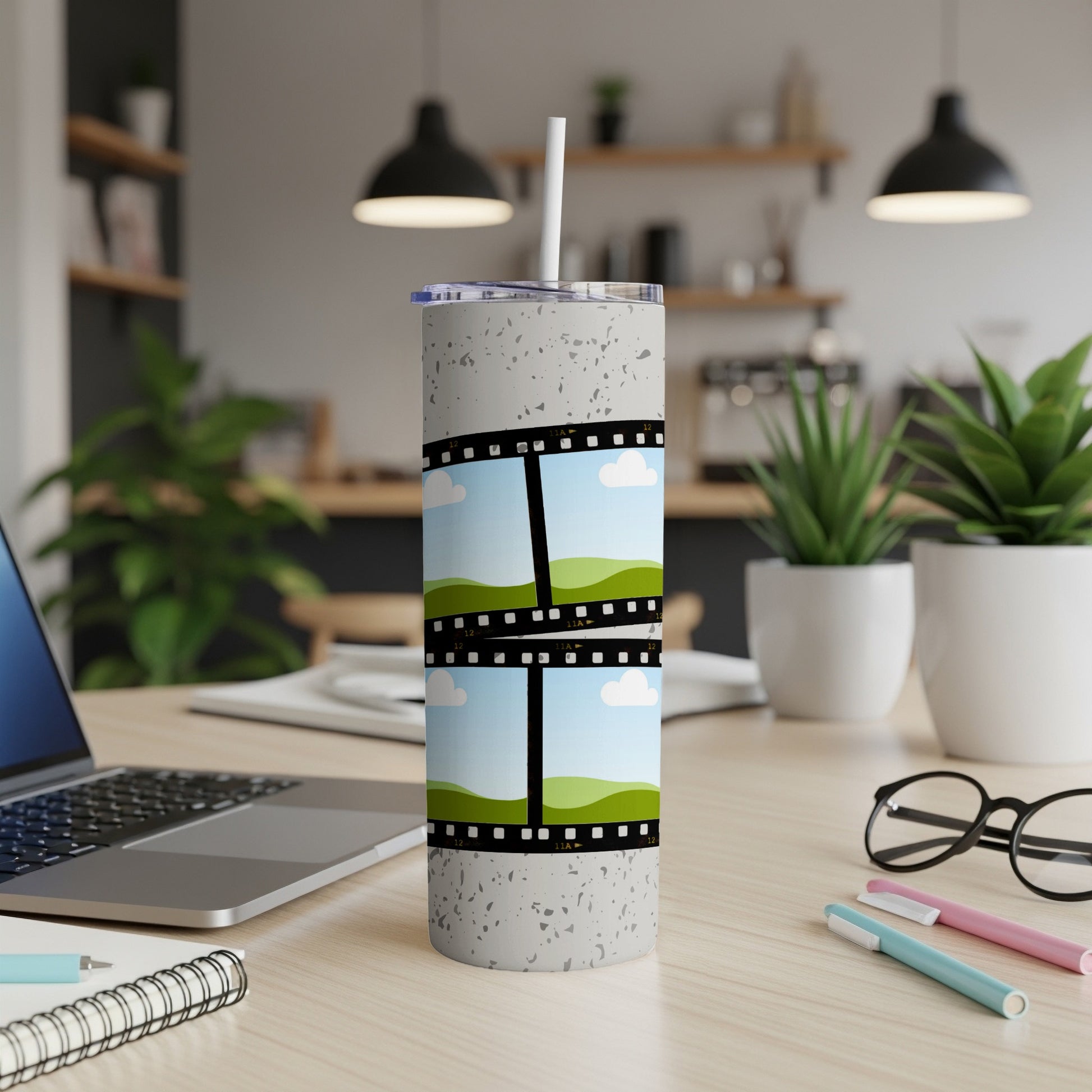 Gray speckled tumbler with film strip design and sky and hills scenes.