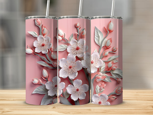 Three pink tumblers with delicate white cherry blossoms on a wooden surface.
