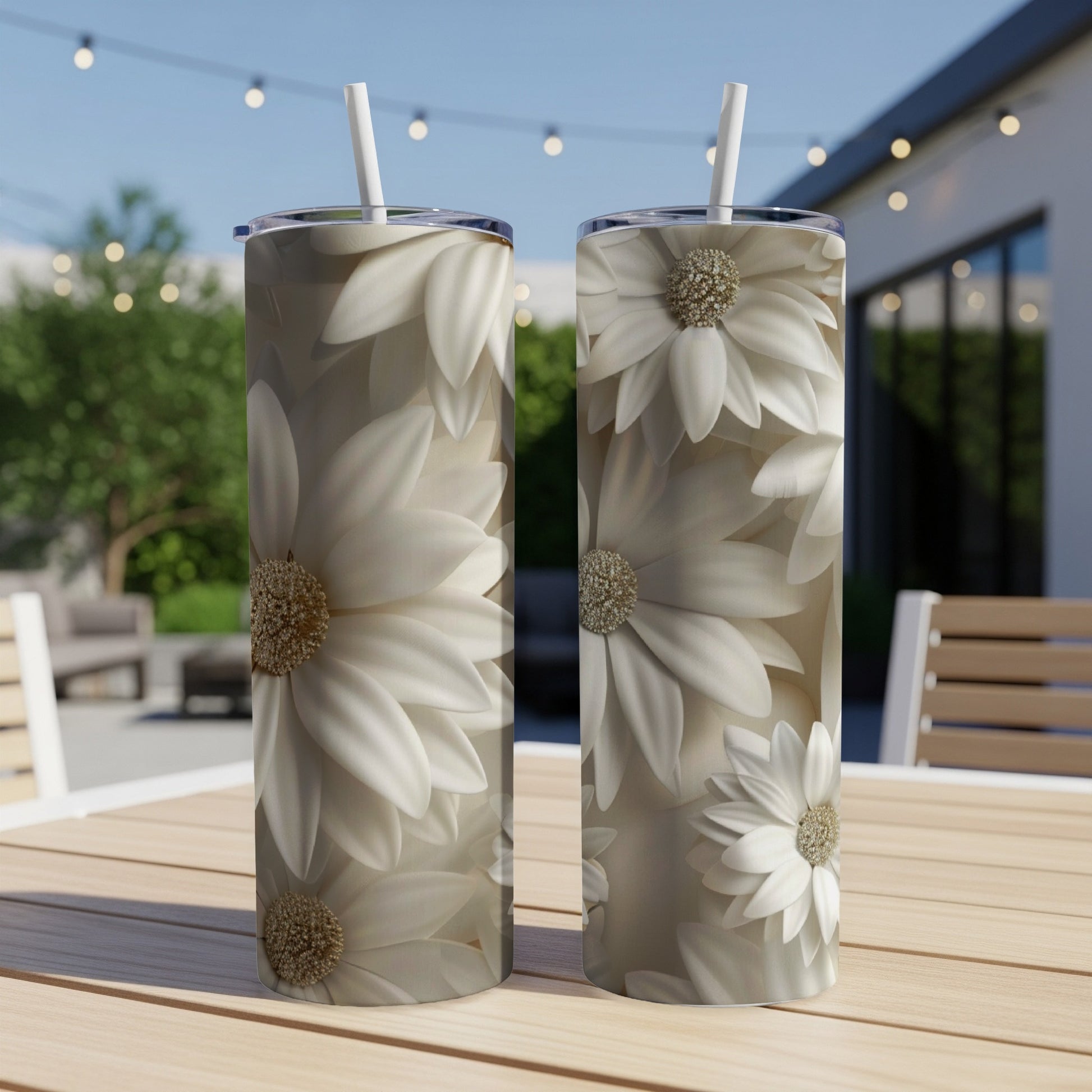 Two white daisy tumblers with straws stand on a wooden table.
