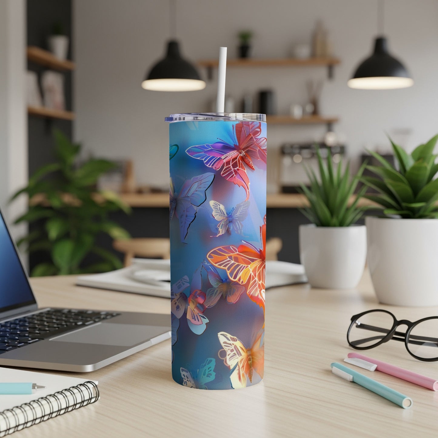 Blue tumbler with colorful butterflies and a white straw.