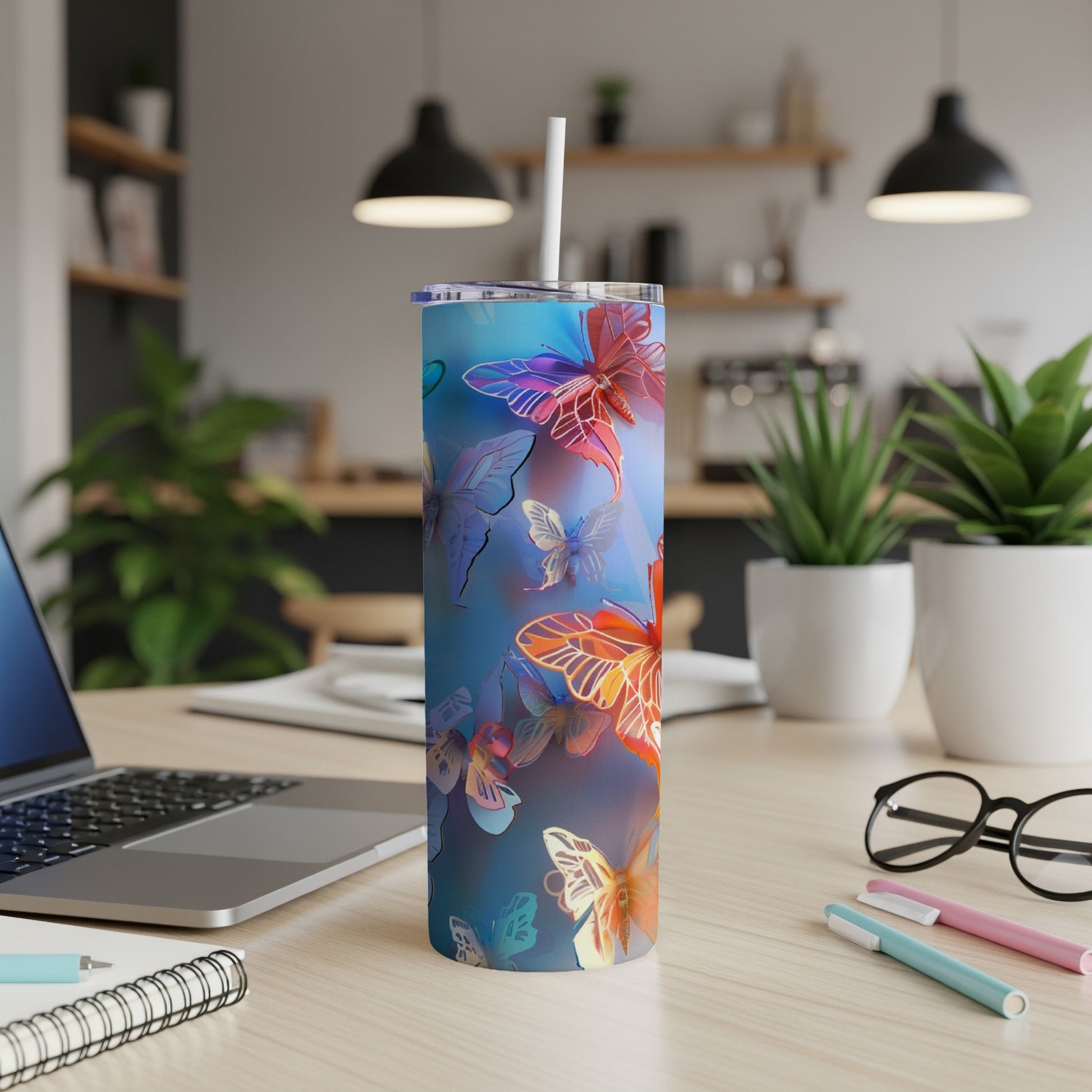 Blue tumbler with colorful butterflies and a white straw.