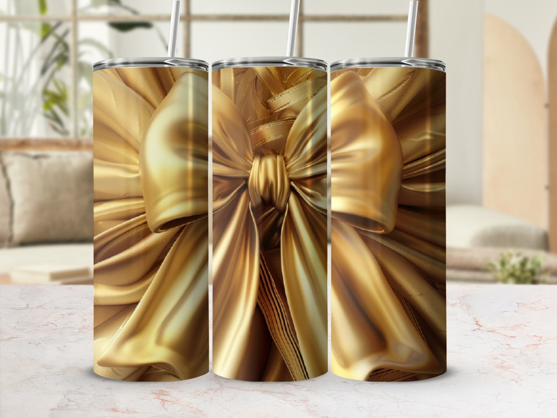 Three gold gift-wrapped tumblers with bows on a marble surface.