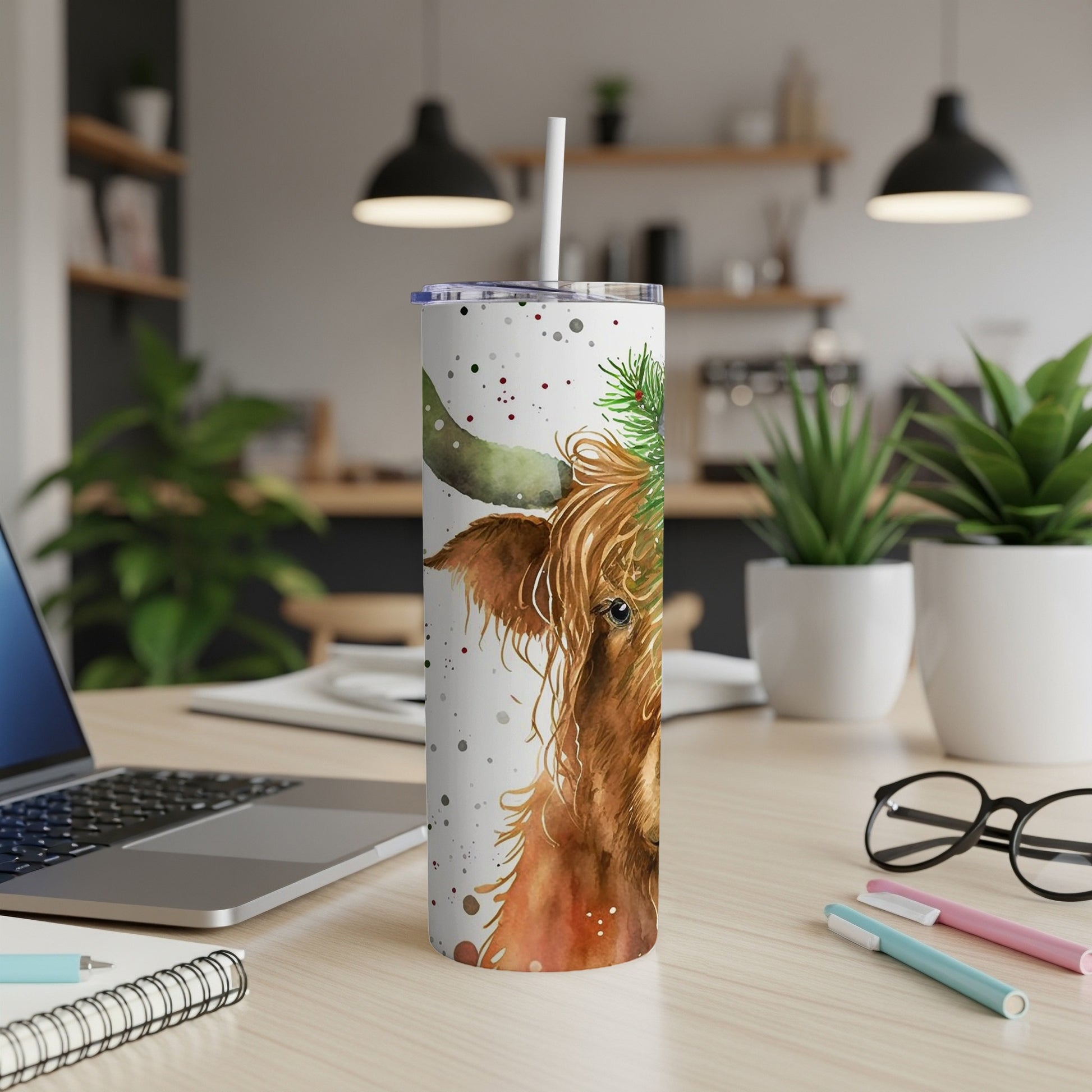 Highland cow tumbler with pine sprigs and snowflakes.