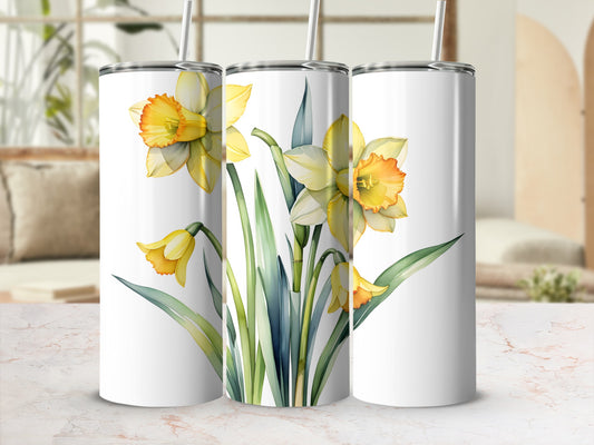 Three white tumblers with daffodils and green leaves.