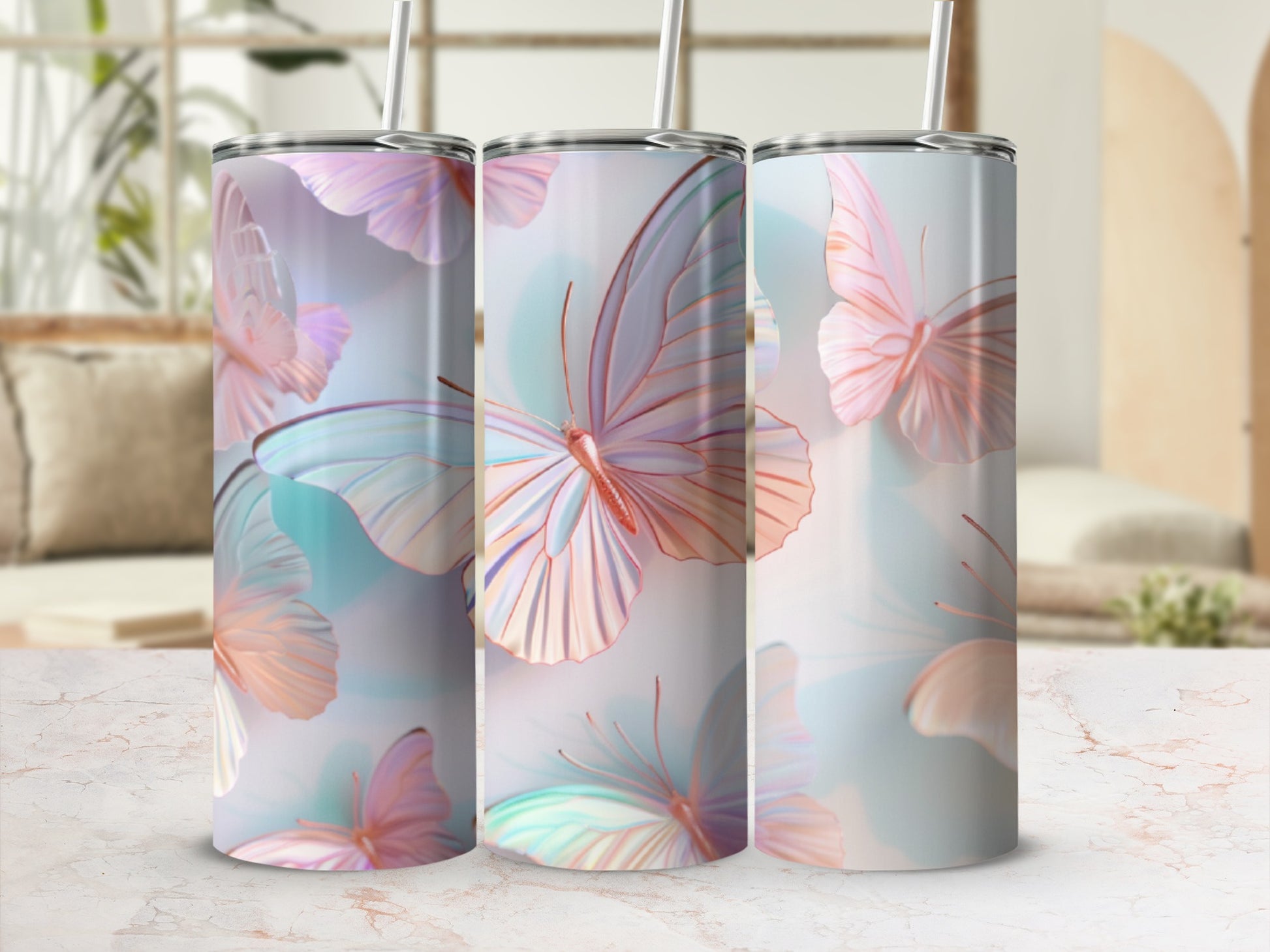 Three tumblers with pastel butterfly designs and straws.