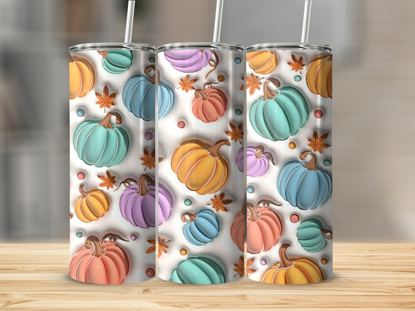 Three colorful, textured pumpkins on white background with subtle fall leaves.