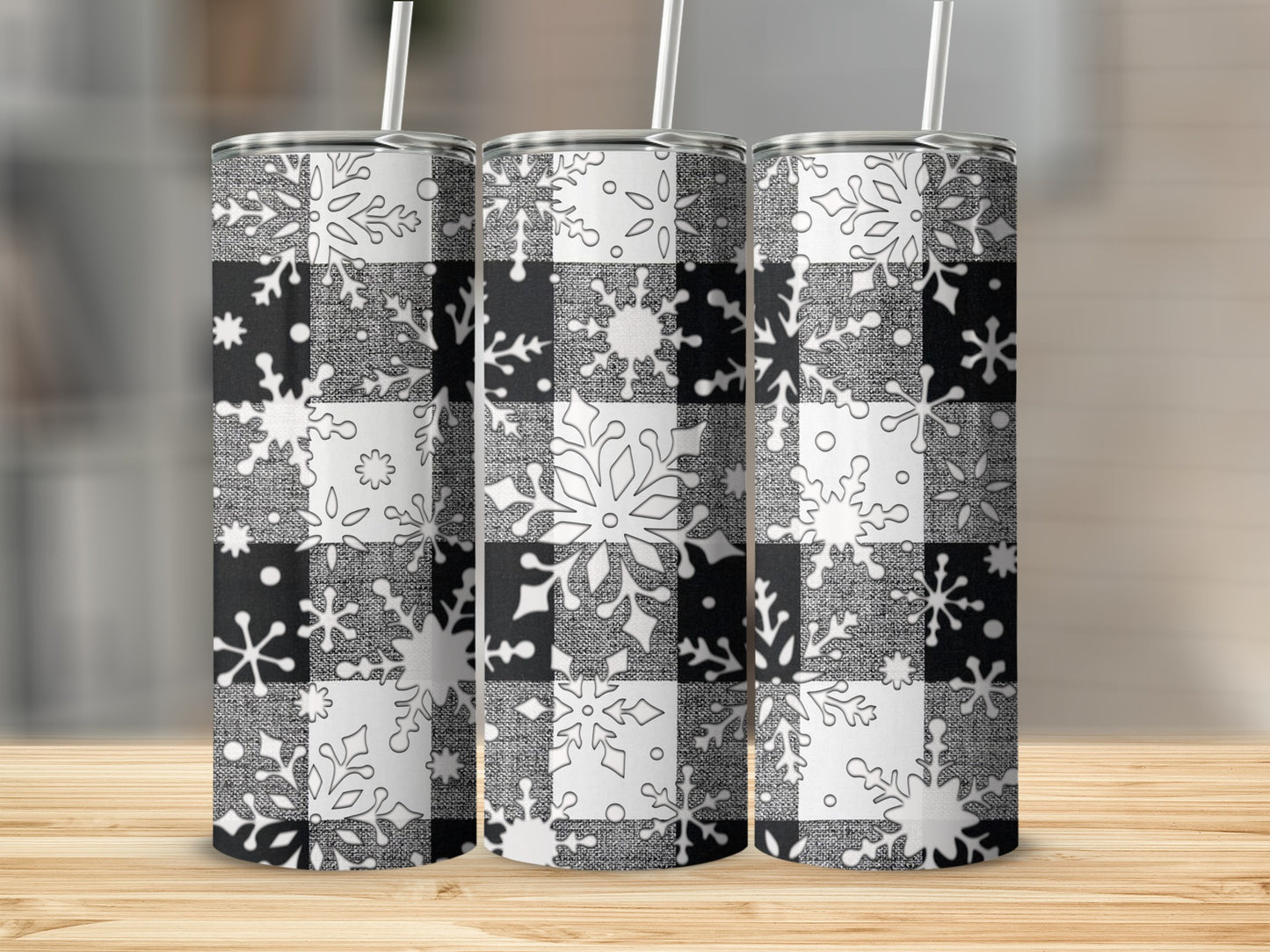 Black and white buffalo plaid with snowflakes tumbler on wooden surface.