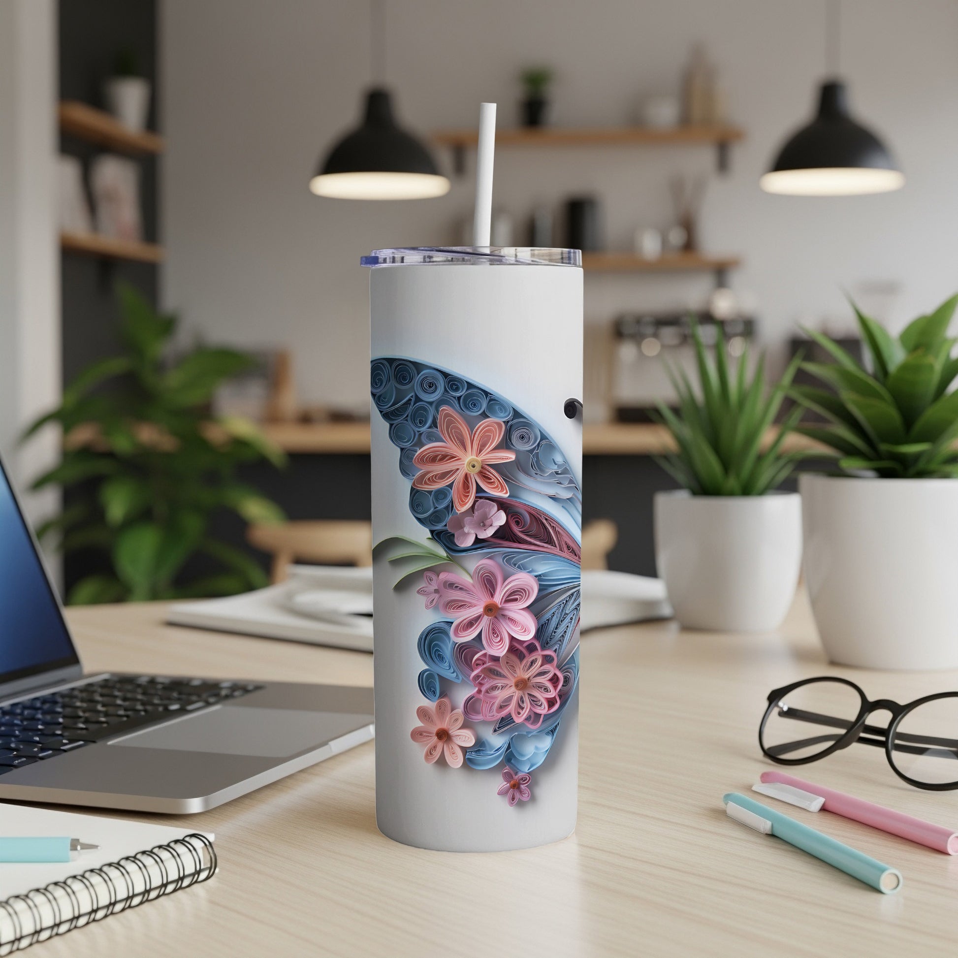 White tumbler with blue and pink quilled butterfly and floral design.
