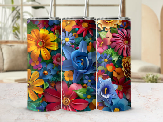 Three tumblers with vibrant floral patterns on a marble countertop.