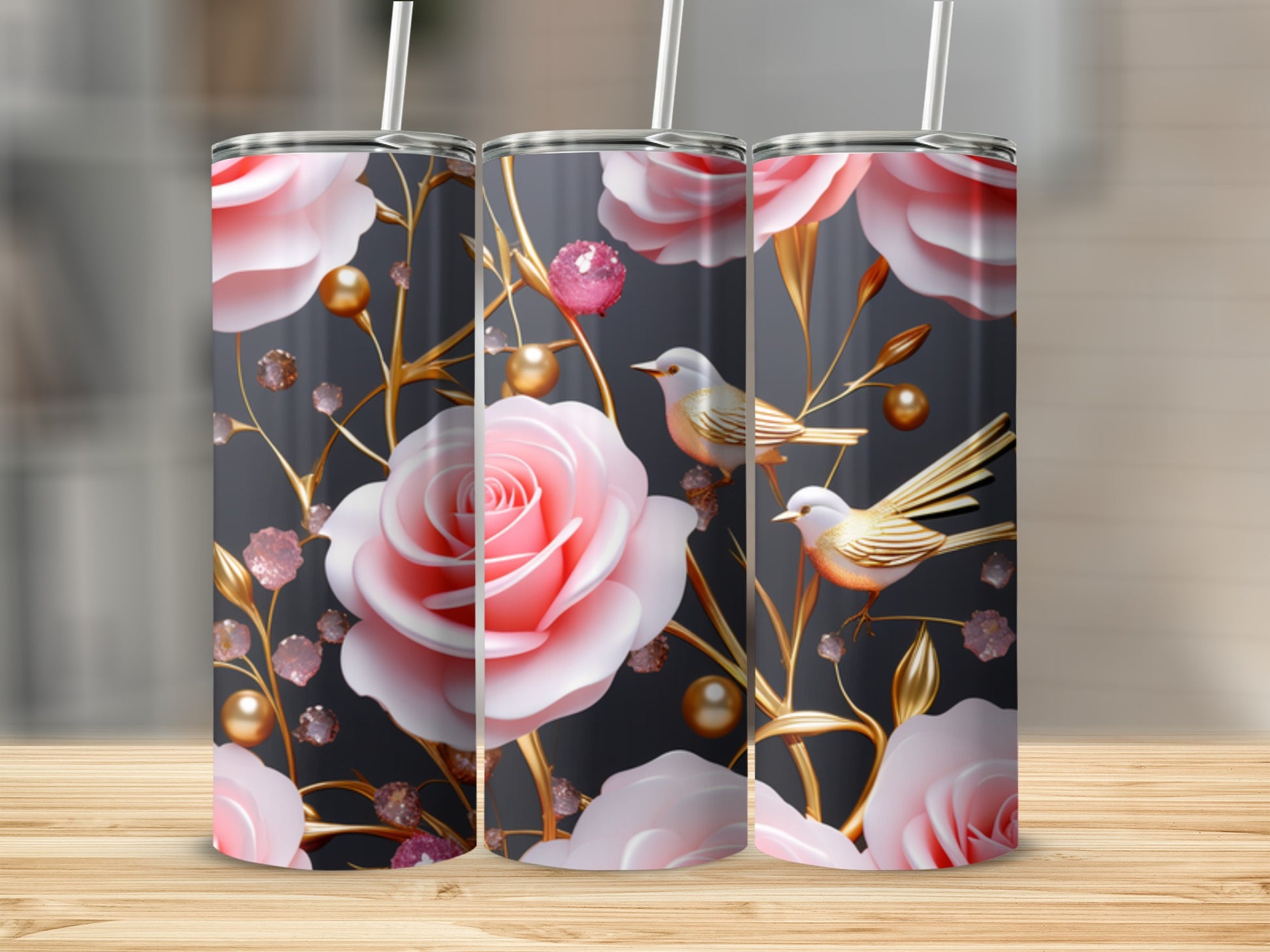 Pink roses and gold birds adorn three tumblers on a wooden surface.