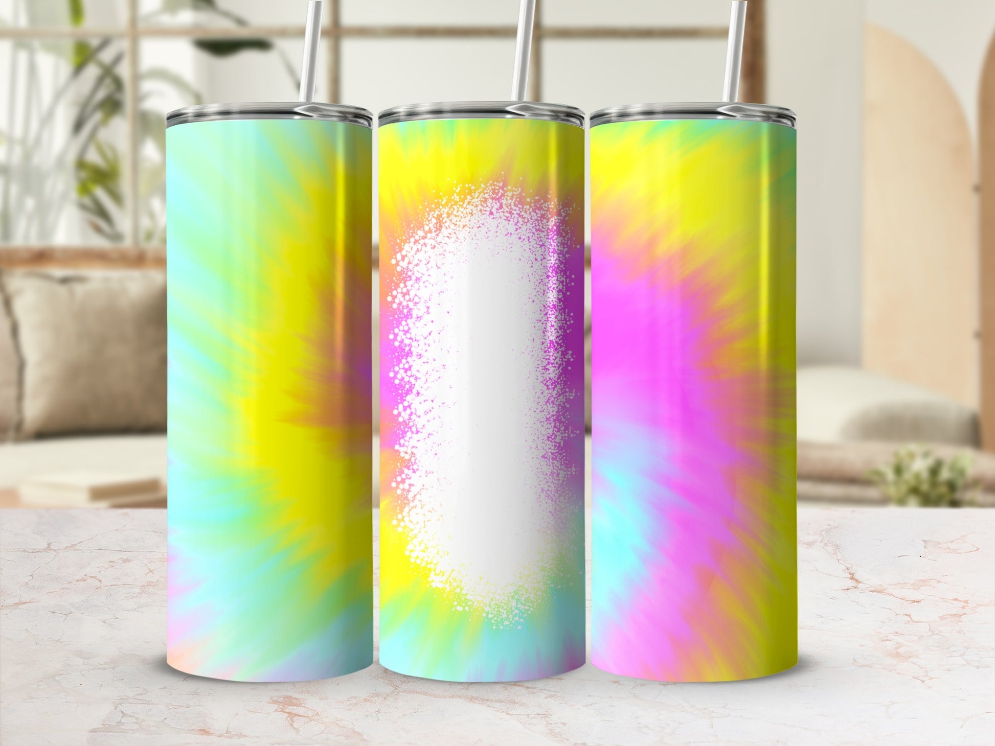 Three tie-dye tumblers with straws, centered on a marble surface.