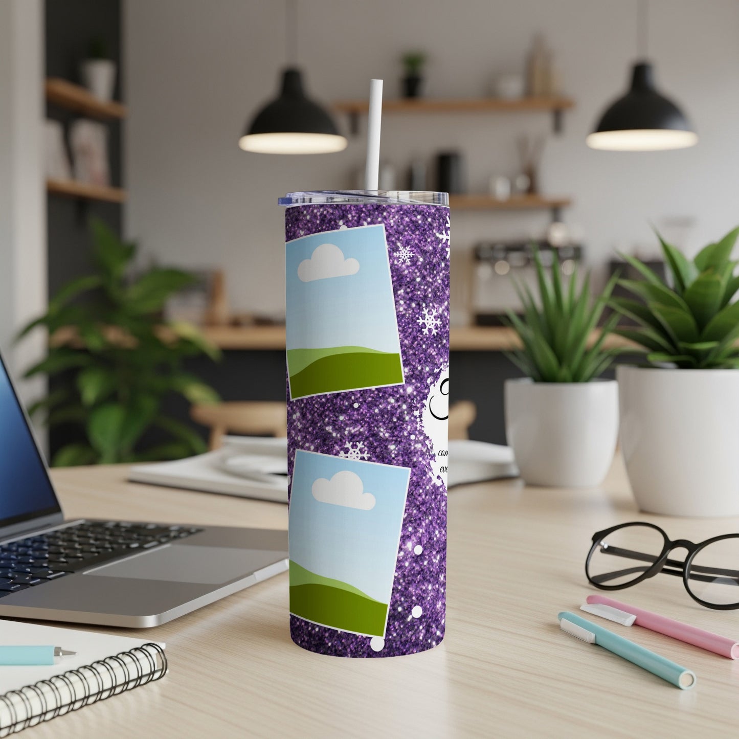 Purple glitter tumbler with photo frames and snowflakes, placed on a desk.