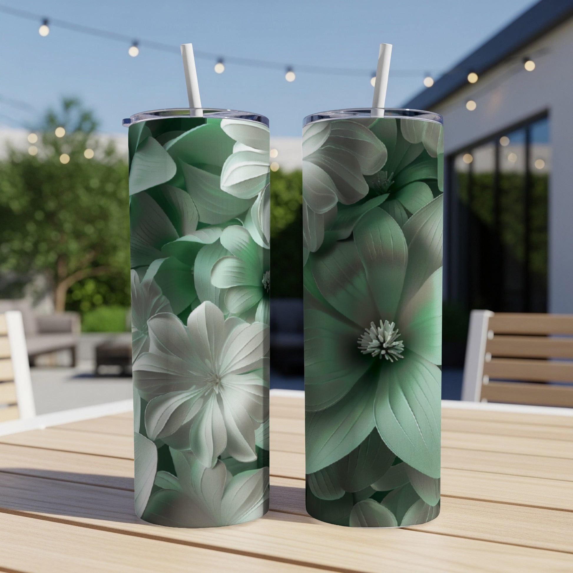 Two tumblers with detailed green floral designs on a wooden table.
