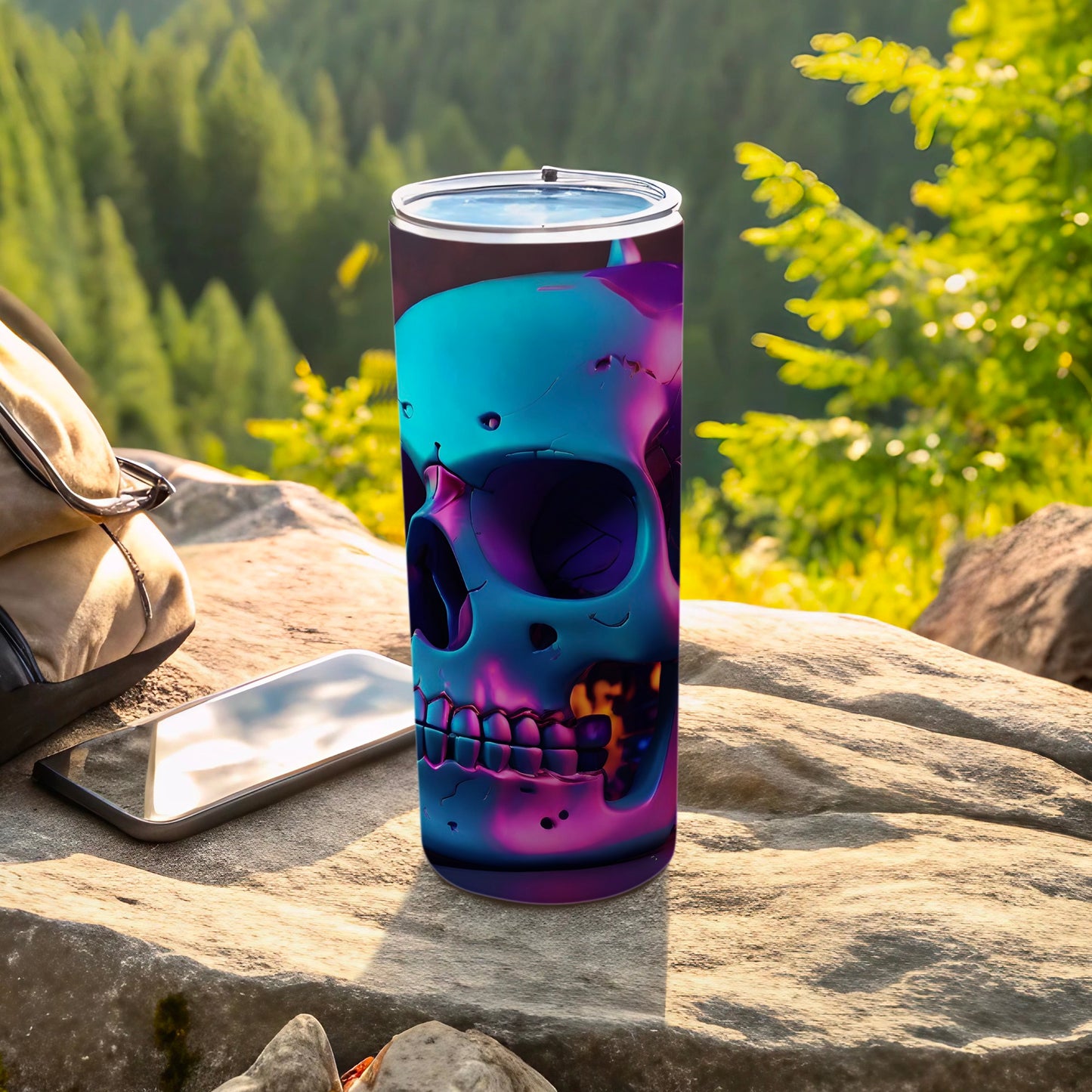 Iridescent skull tumbler on rock with phone and backpack, forest background.