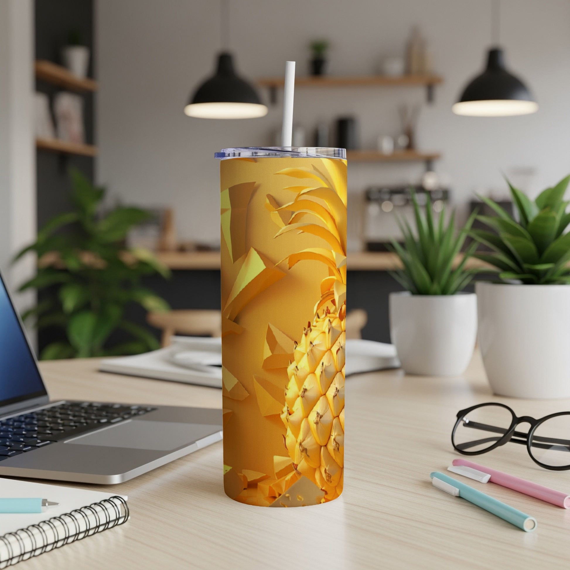 Yellow pineapple design on a gold tumbler with a straw.