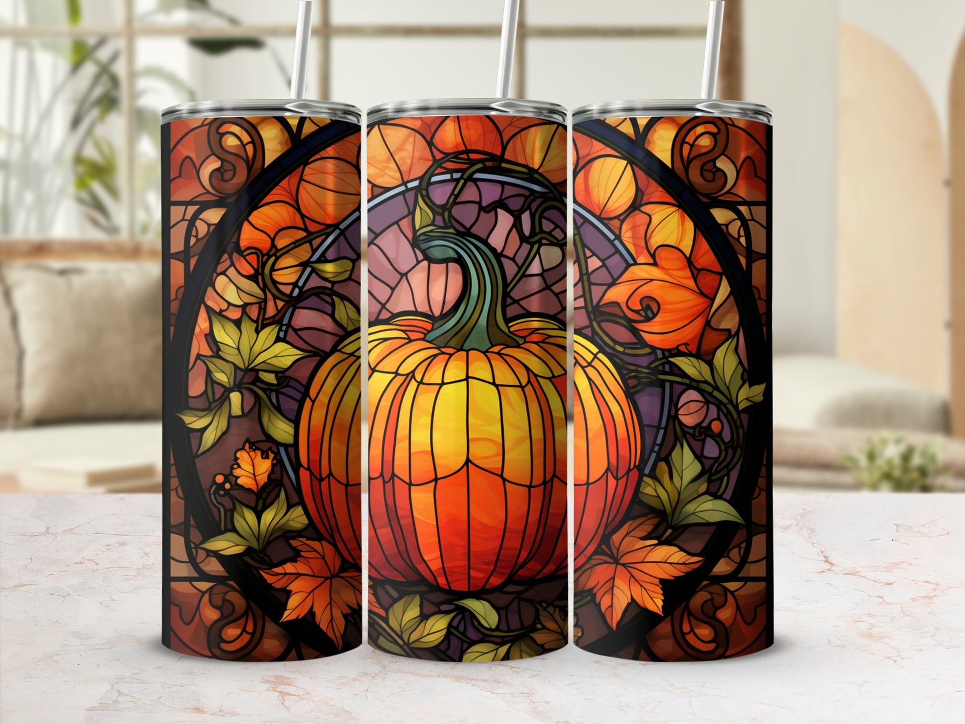 Pumpkin and autumn leaves design on three tumblers with straws.