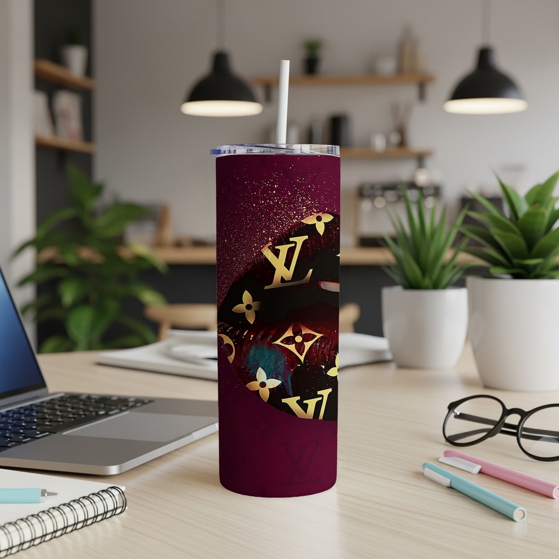 Maroon tumbler with gold LV pattern and glitter detail.