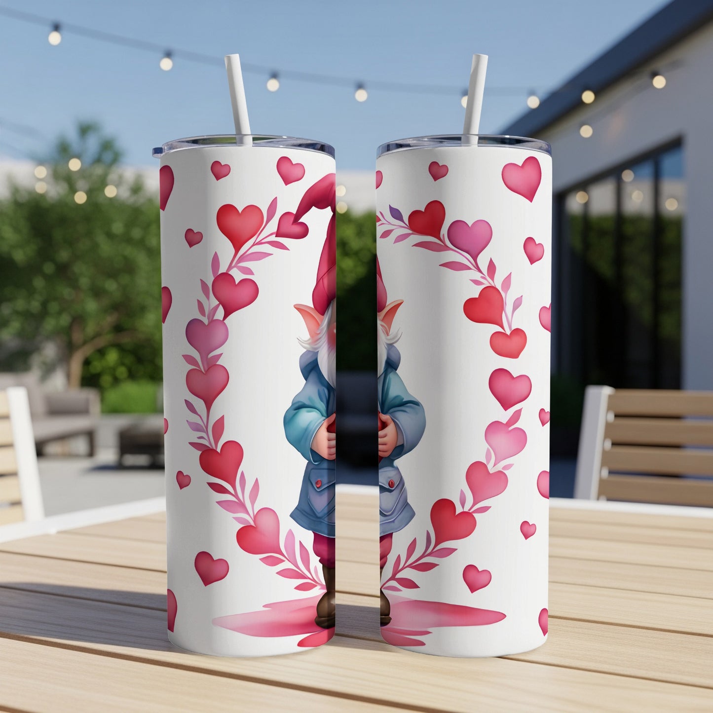 Two tumblers with a gnome and heart pattern on an outdoor table.