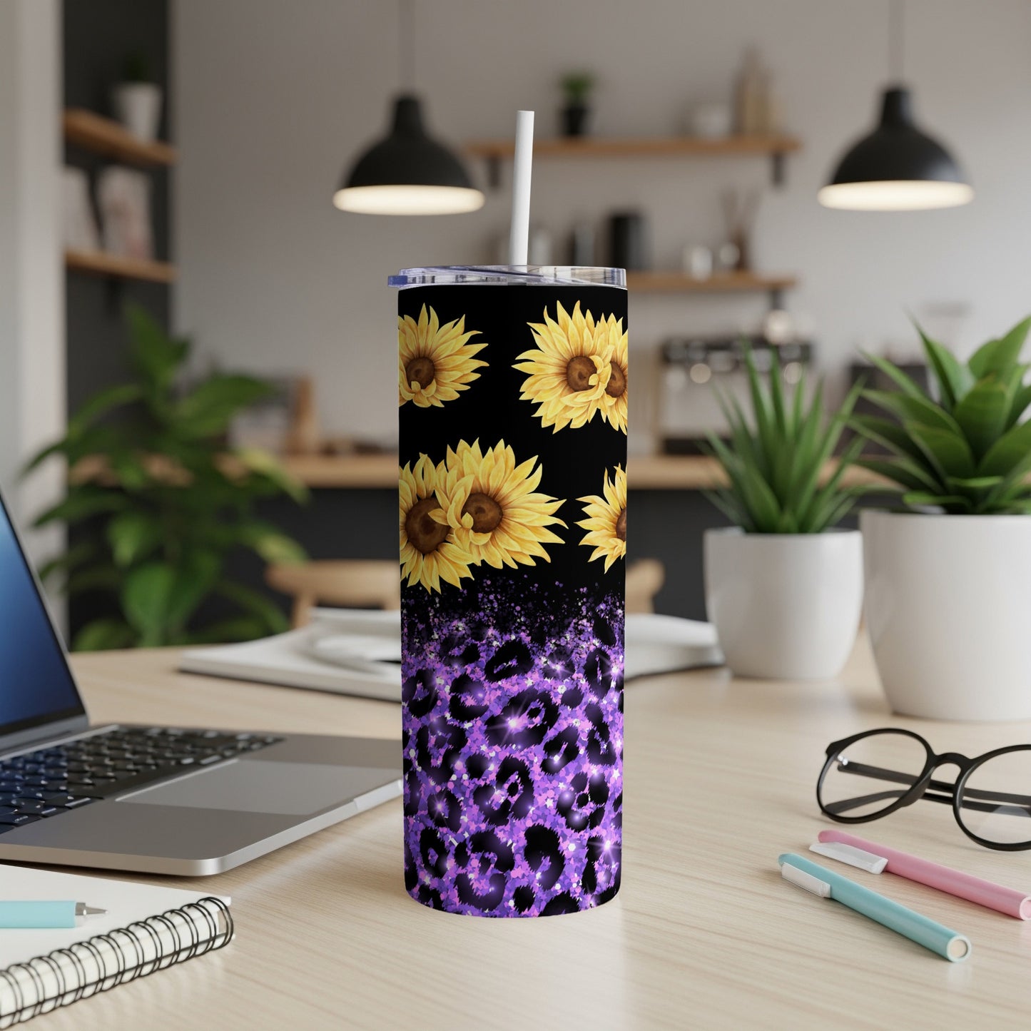 Purple leopard print tumbler with sunflowers on a desk.