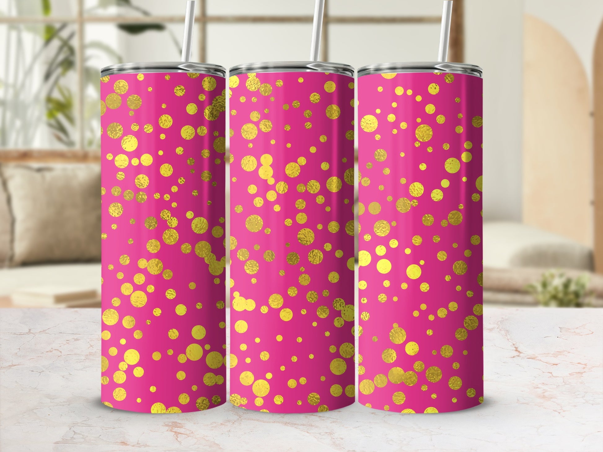 Three pink tumblers with gold polka dot design and white straws.