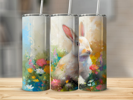 Watercolor bunny in a field of colorful flowers, printed on three tumblers.