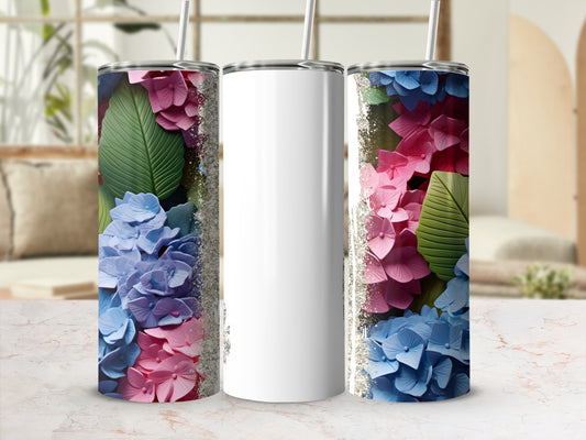 White tumbler with pink and blue hydrangeas and green leaves.