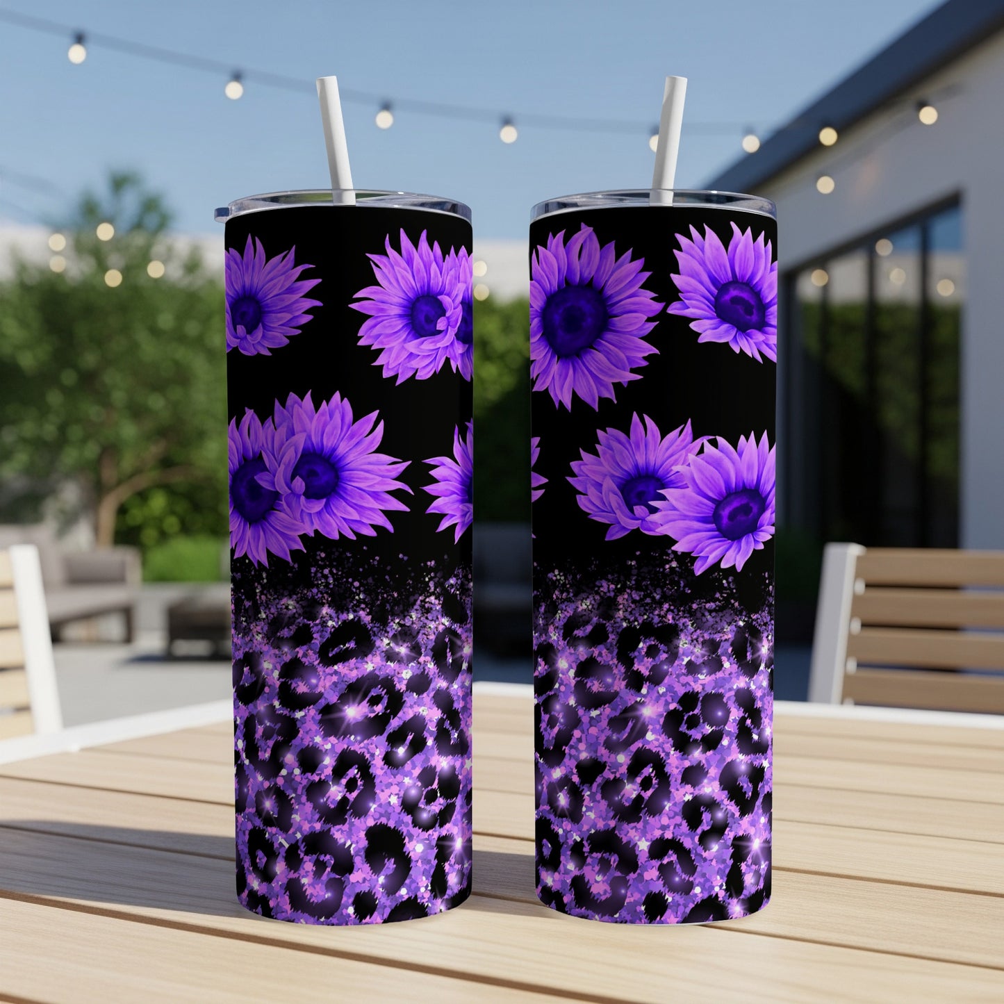 Two purple floral tumblers with leopard print on a table outdoors.