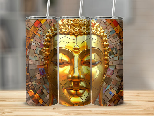 Golden Buddha face tumbler with mosaic background on wooden table.