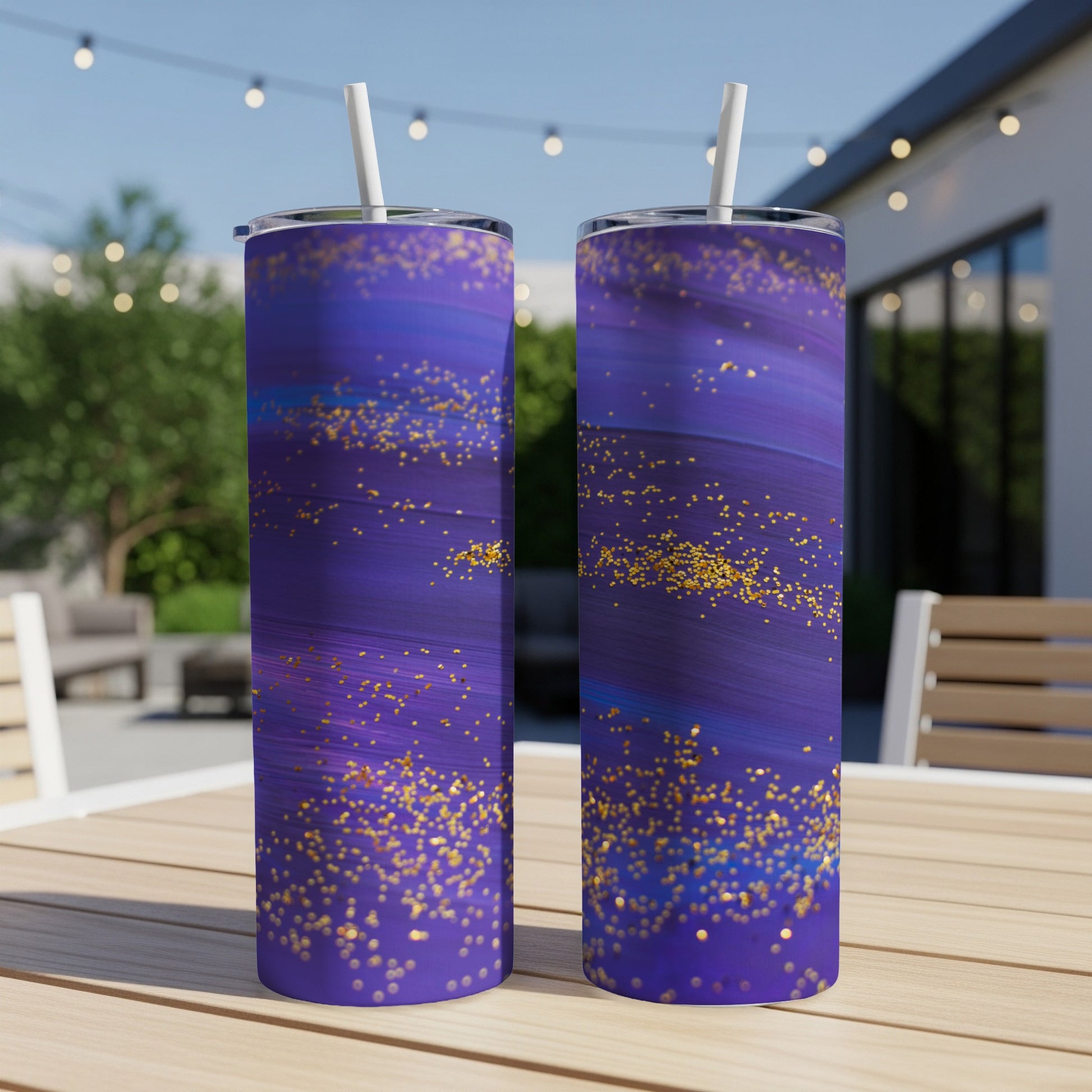 Two tall tumblers with purple and blue brushstrokes and gold glitter accents.