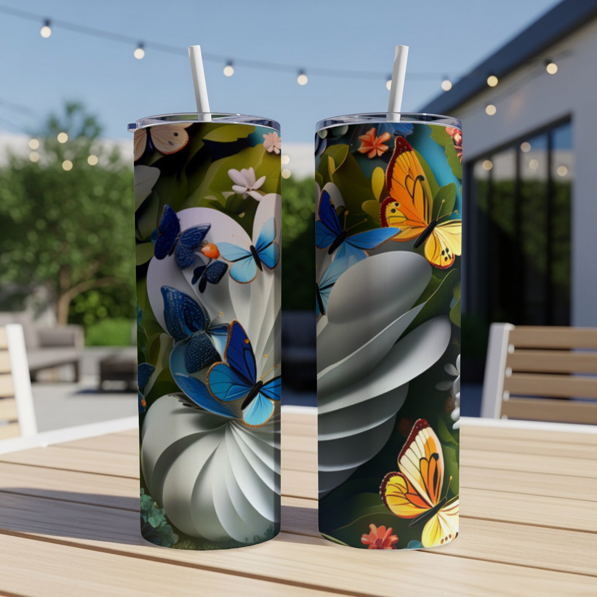 Two tumblers with a colorful butterfly and floral design on a table.