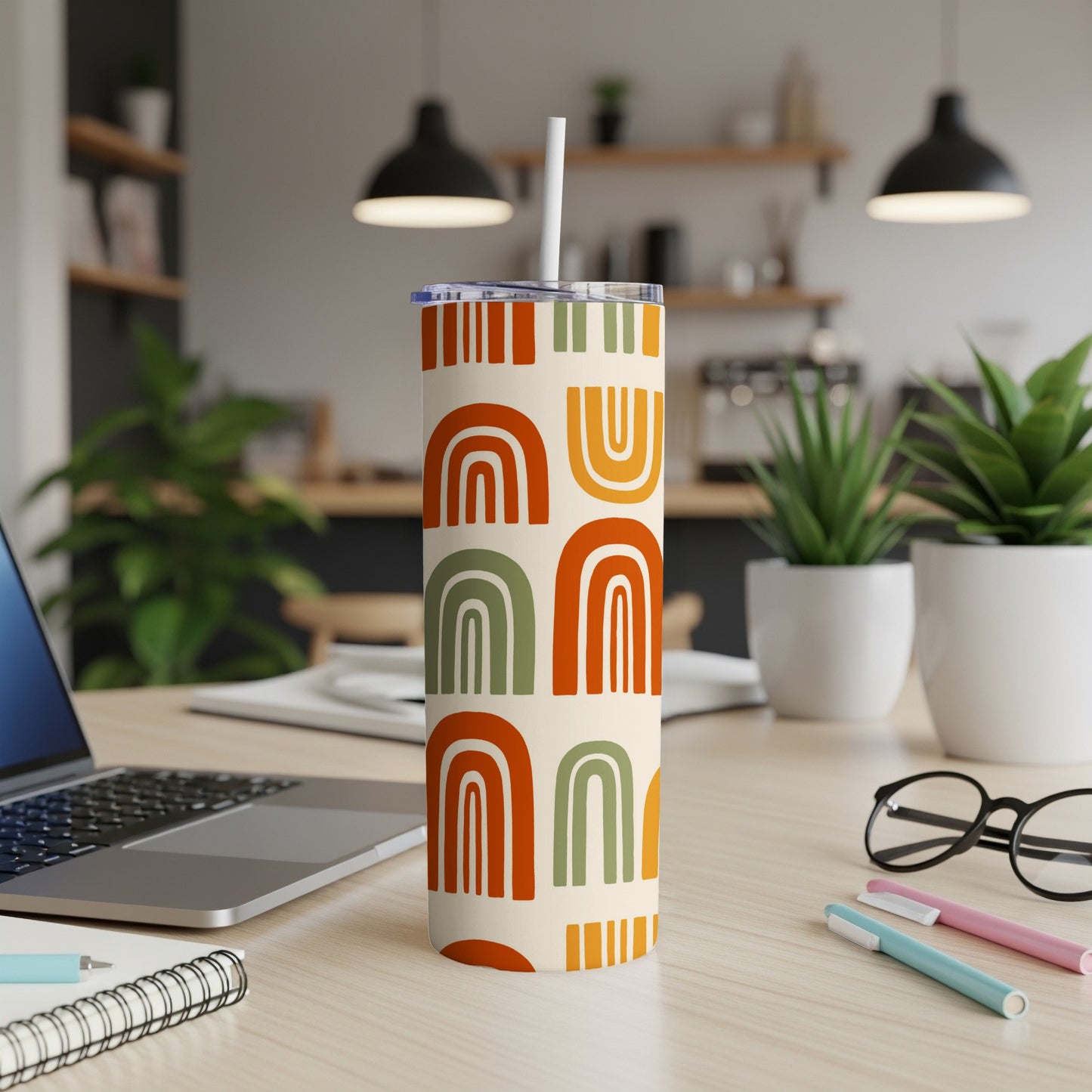 Tall tumbler with abstract rainbow pattern in cream, orange, green, and yellow.