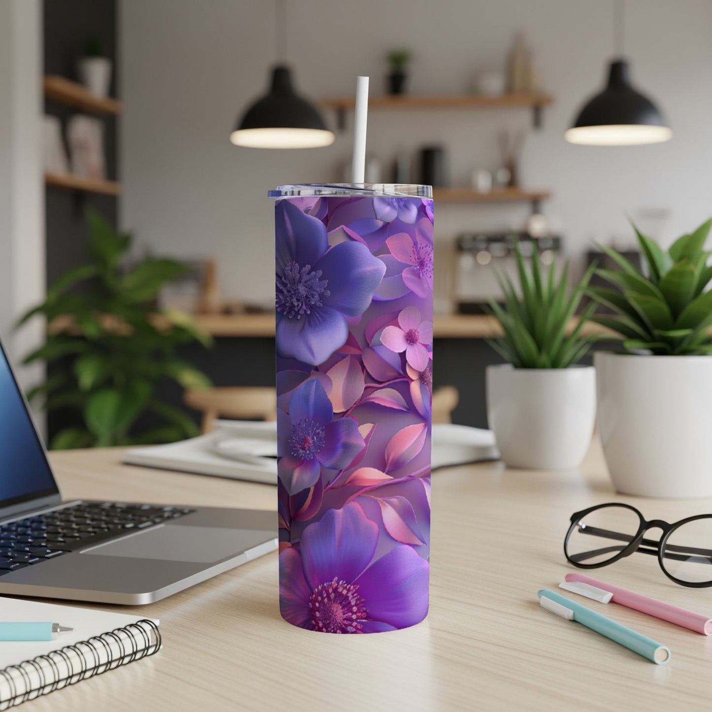 Purple floral patterned tumbler with straw on a desk.