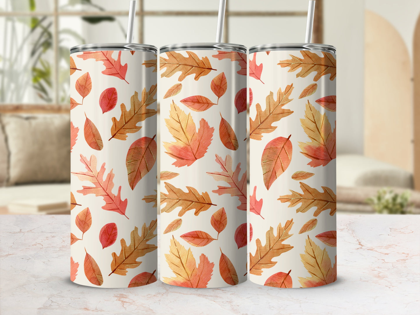 Three tumblers with an autumn leaf pattern on a marbled surface.