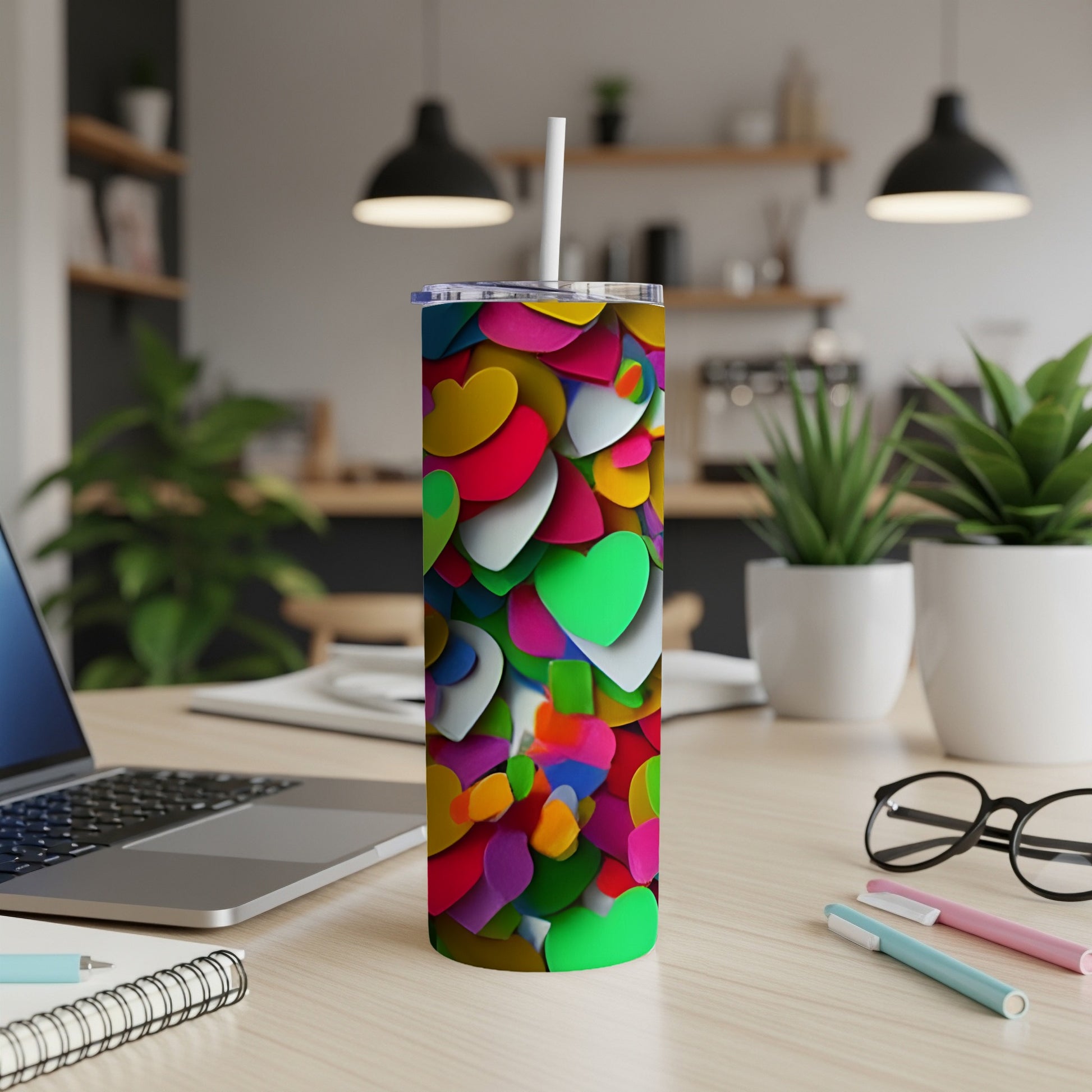 Multi-colored heart pattern on a tall, slender tumbler with a straw.