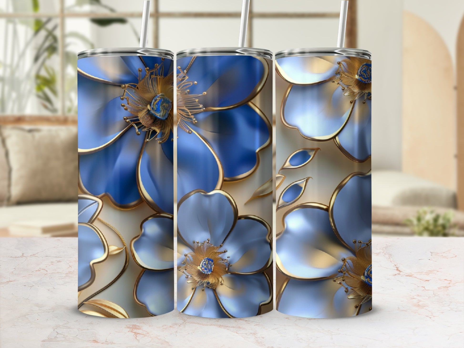 Three blue floral tumblers with gold accents on a white marble surface.