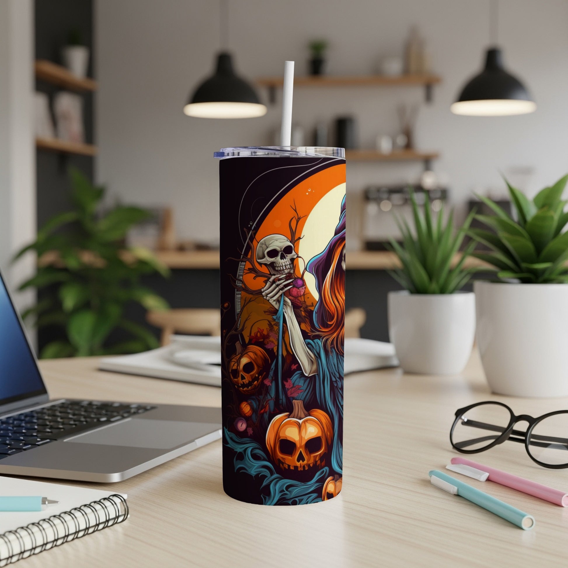Tall tumbler with Halloween design featuring a skeleton, witch, and pumpkins.