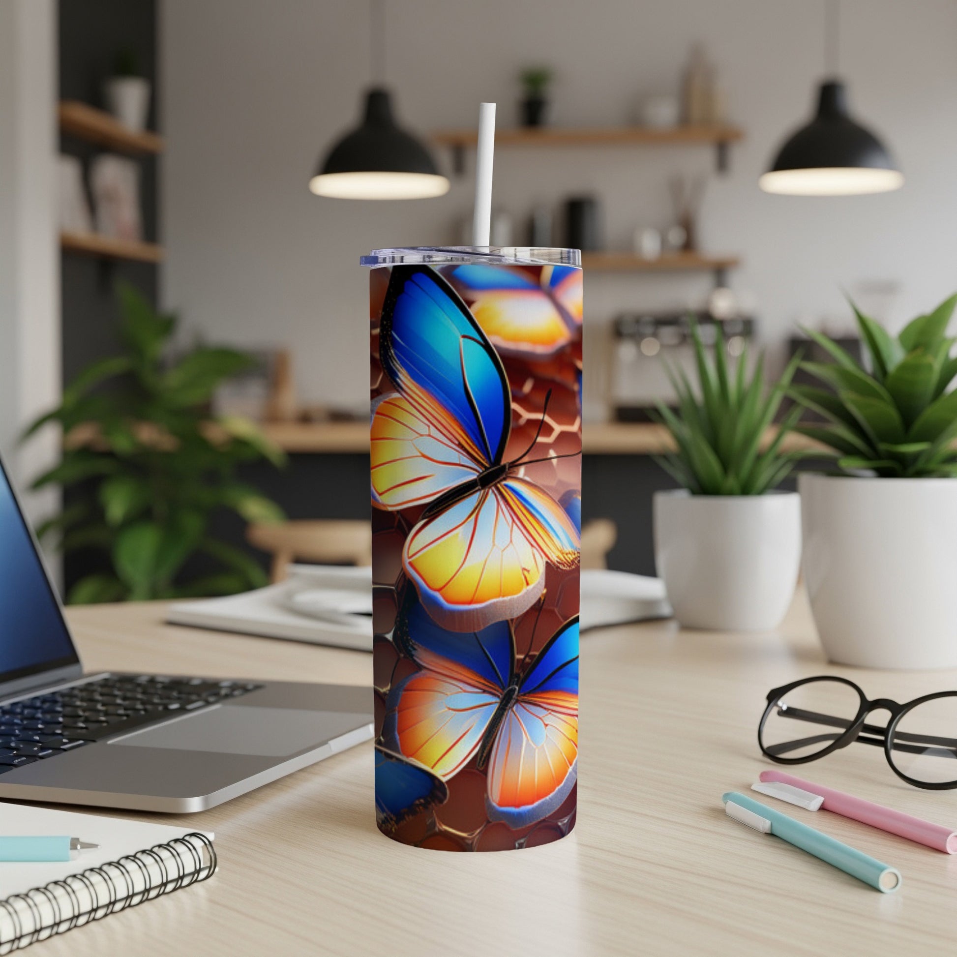 Tall tumbler with colorful butterfly pattern, white straw, on a desk.