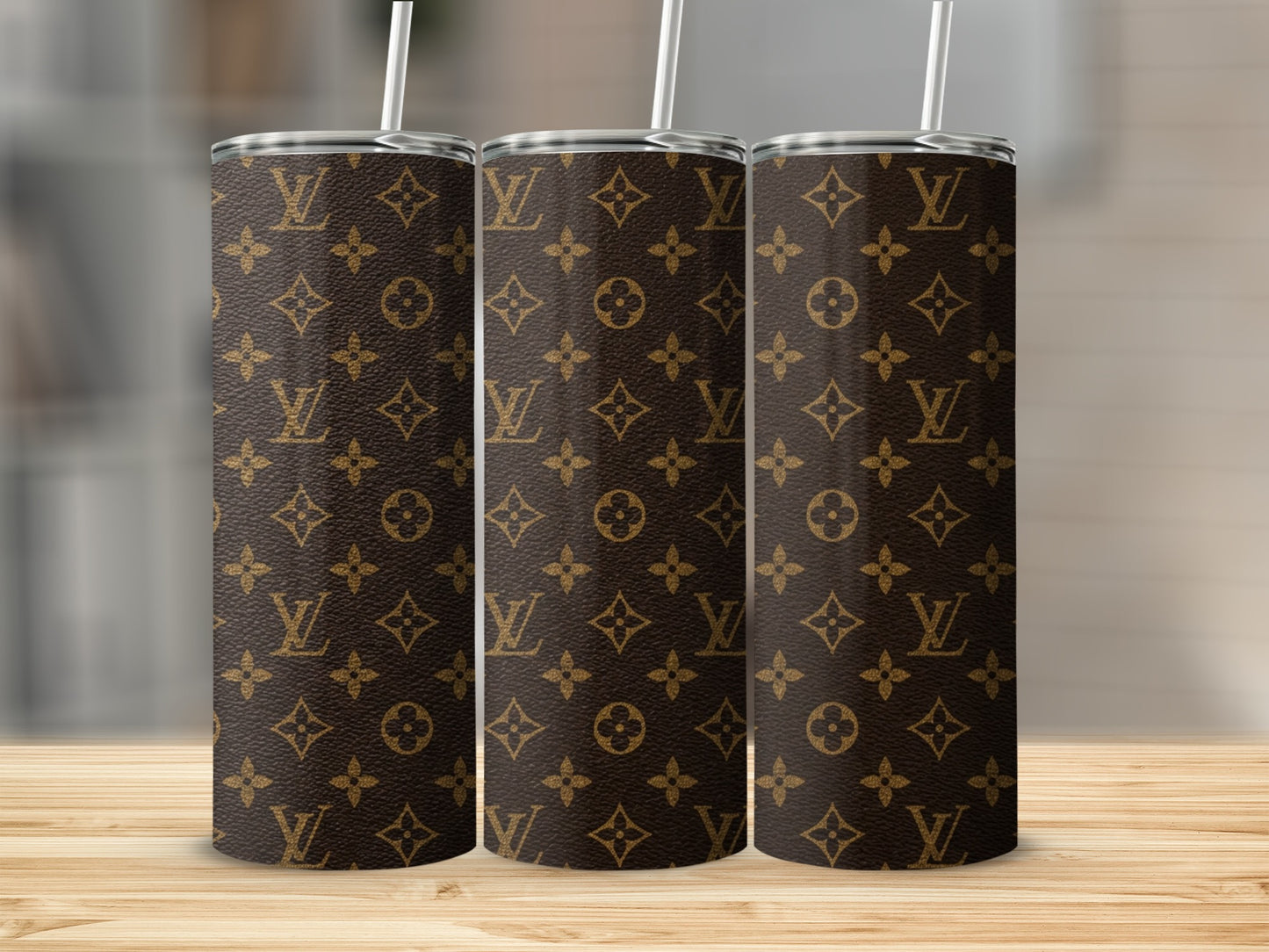 Trio of brown tumblers with repeating Louis Vuitton monogram pattern.