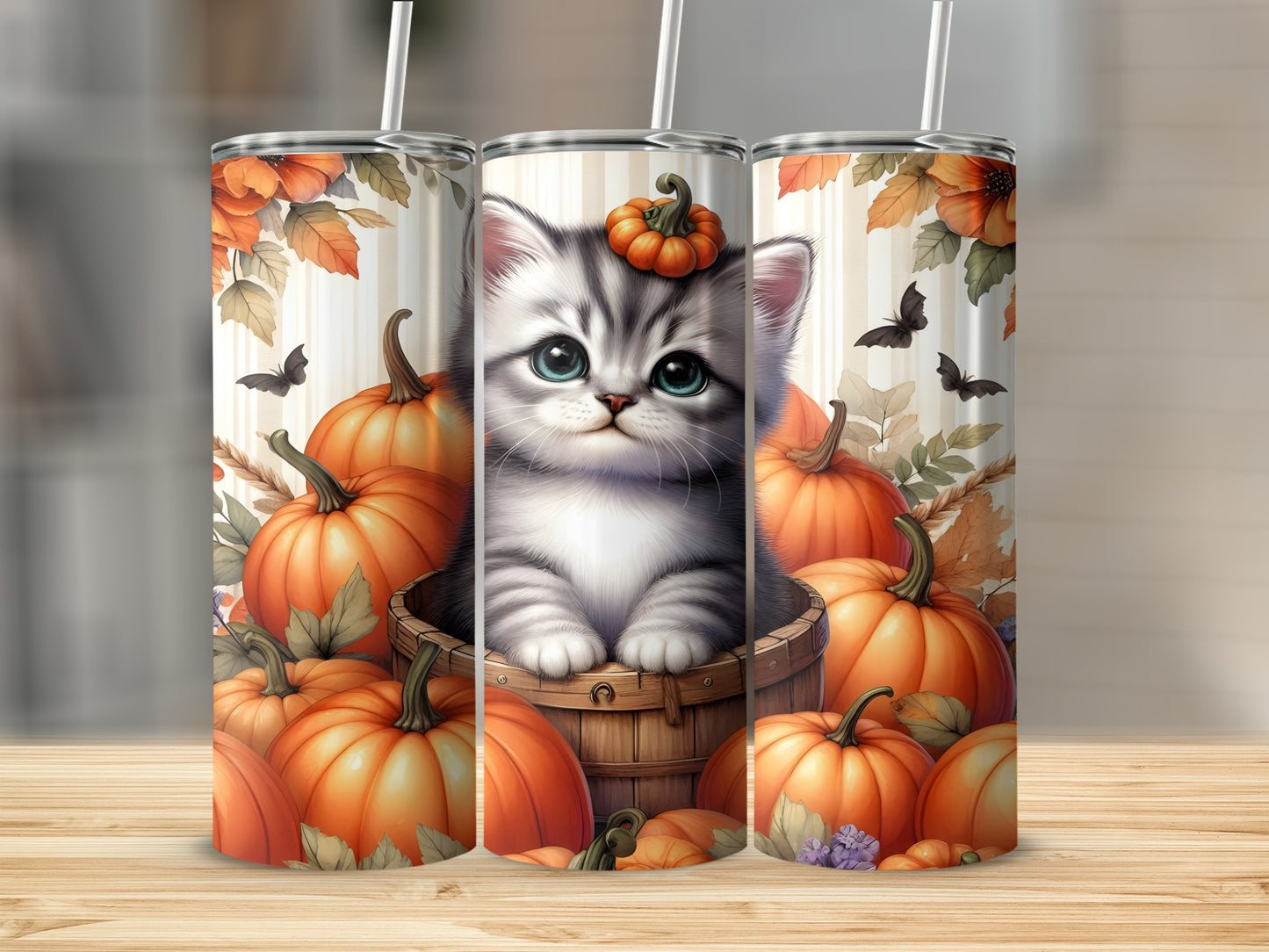 Kitten with pumpkins and autumn leaves on a tumbler.