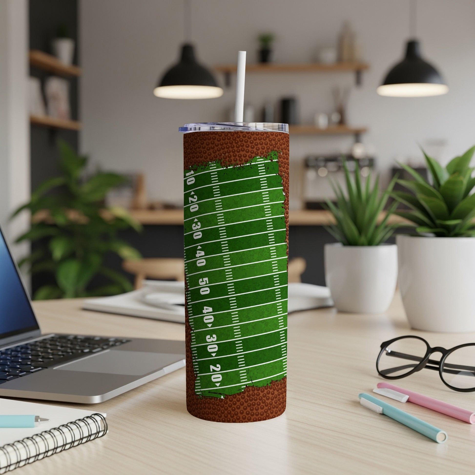 Football field themed tumbler with a straw and office desk accessories.