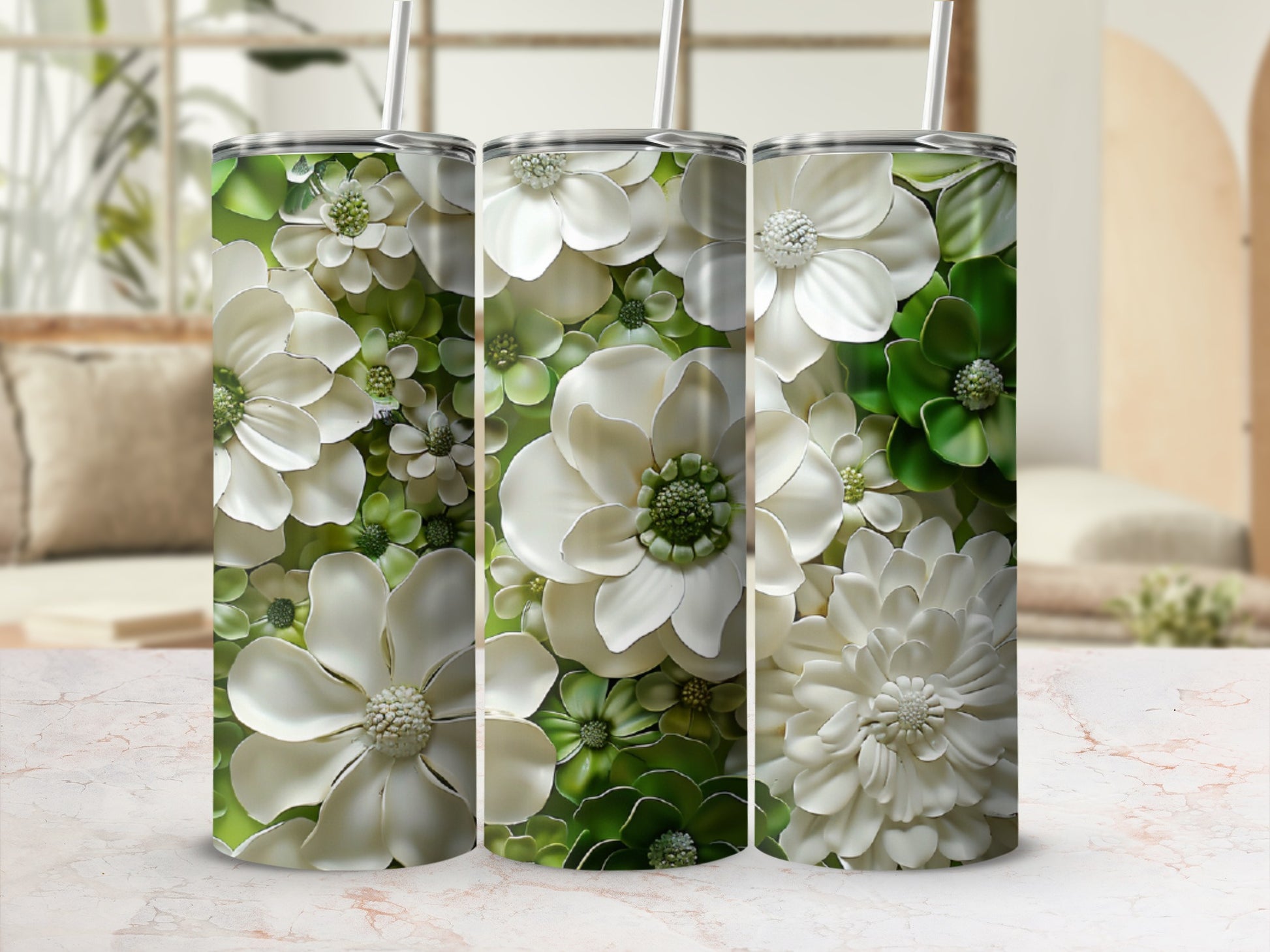 Three tumblers with a white and green floral pattern and straws.