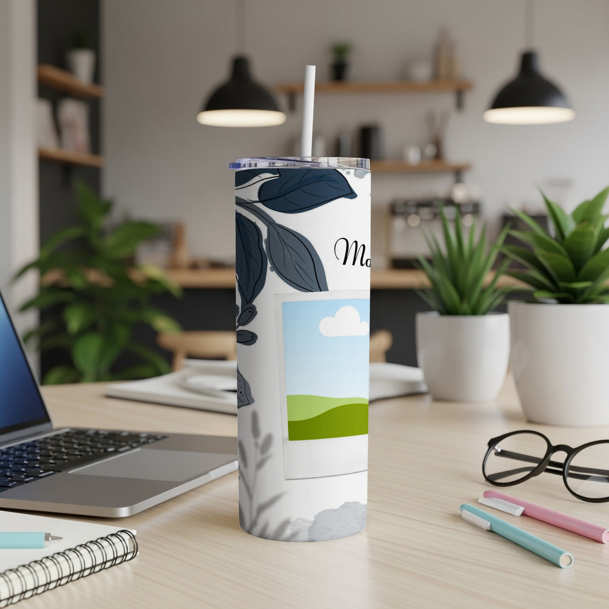 Tumbler with floral design, a photo frame, and text "Mom" on a desk.