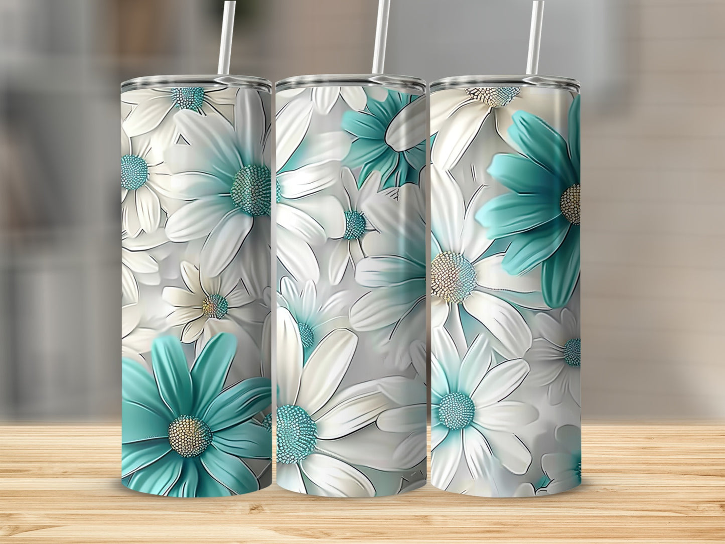 Three tumblers with teal and white floral pattern on wooden surface.