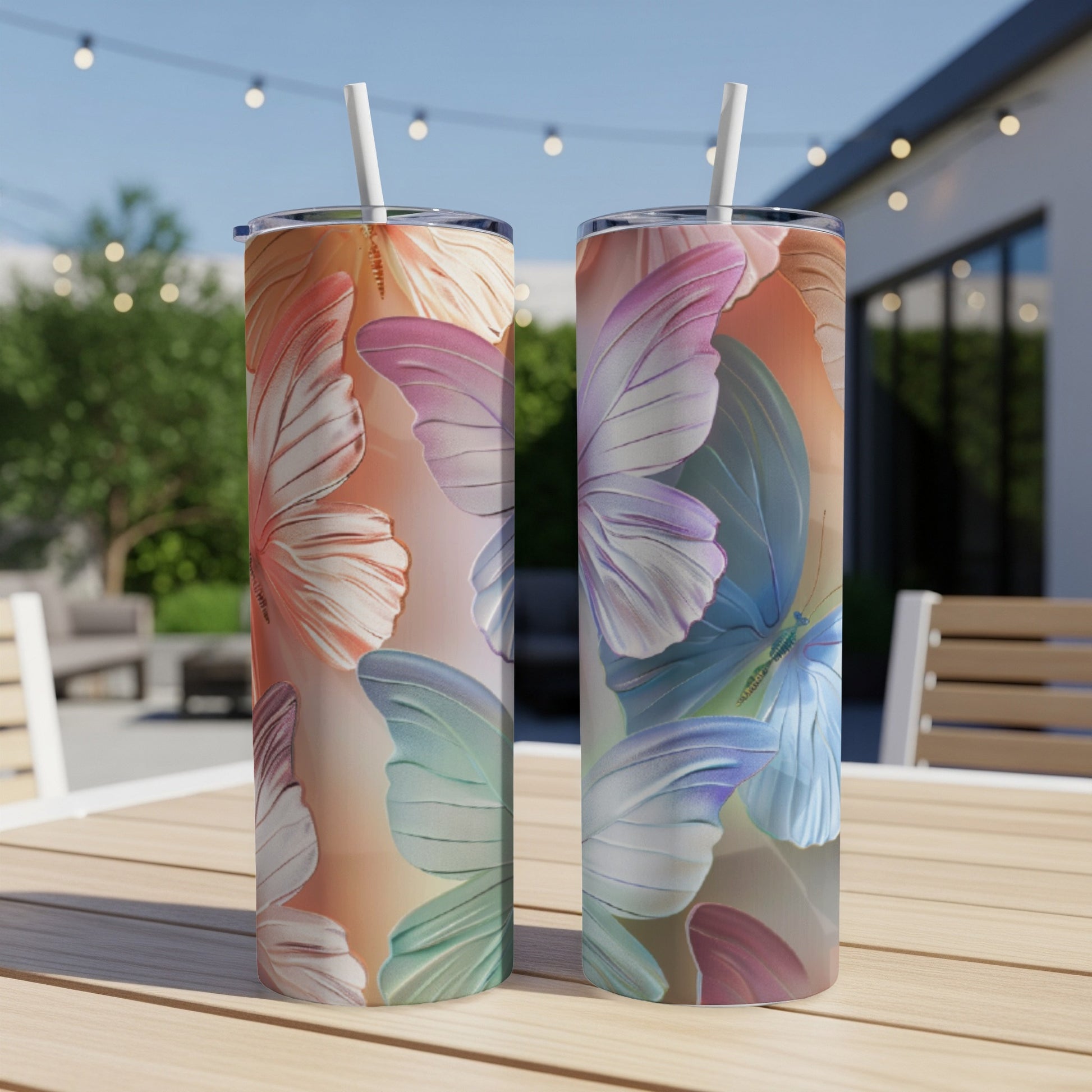 Two tumblers with pastel butterfly wing designs sit on a wooden table.