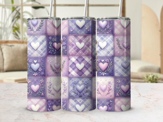 Three purple and pink patchwork heart tumblers with lids and straws.