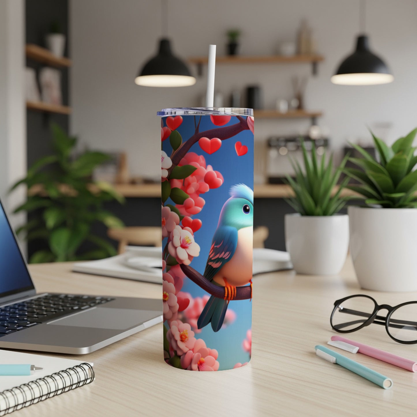 Blue bird perched on a branch with pink blossoms and hearts, on a tumbler.