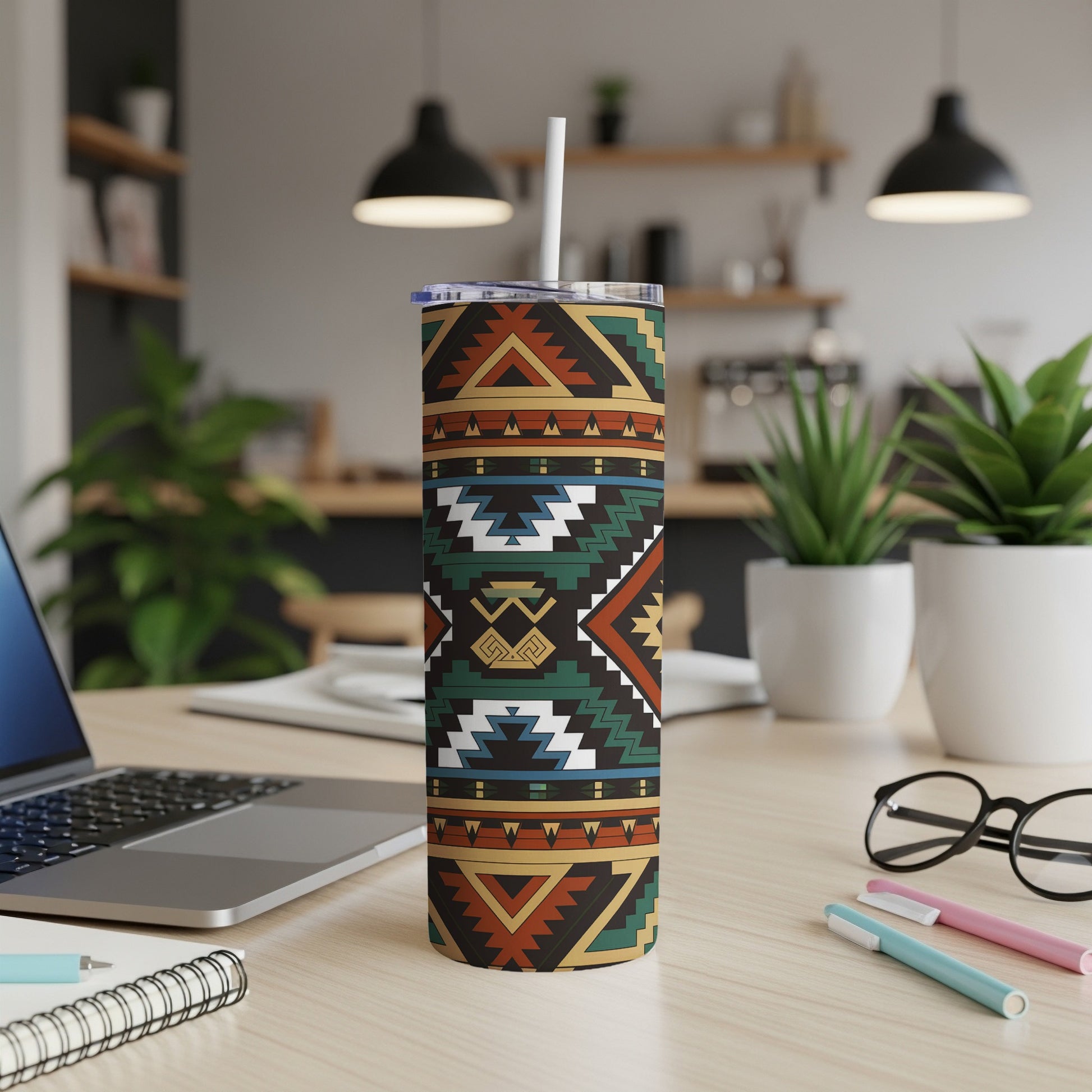 Geometric patterned tumbler with straw on a desk.