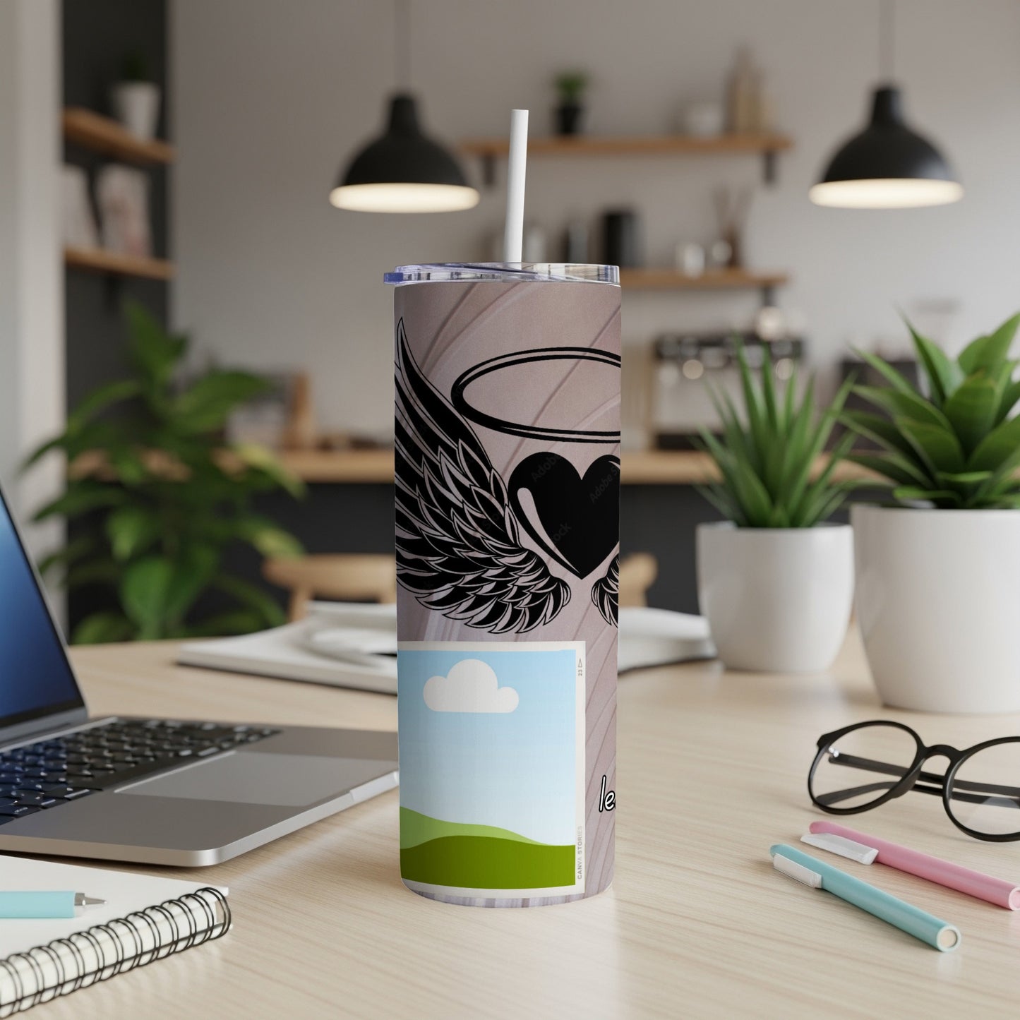 Tall tumbler with angel wing heart design and a nature scene graphic.