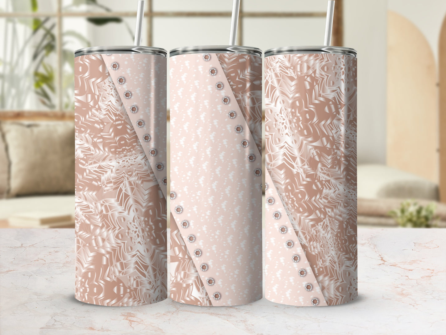 Three rose gold patterned tumblers with straw, displayed on a marble surface.