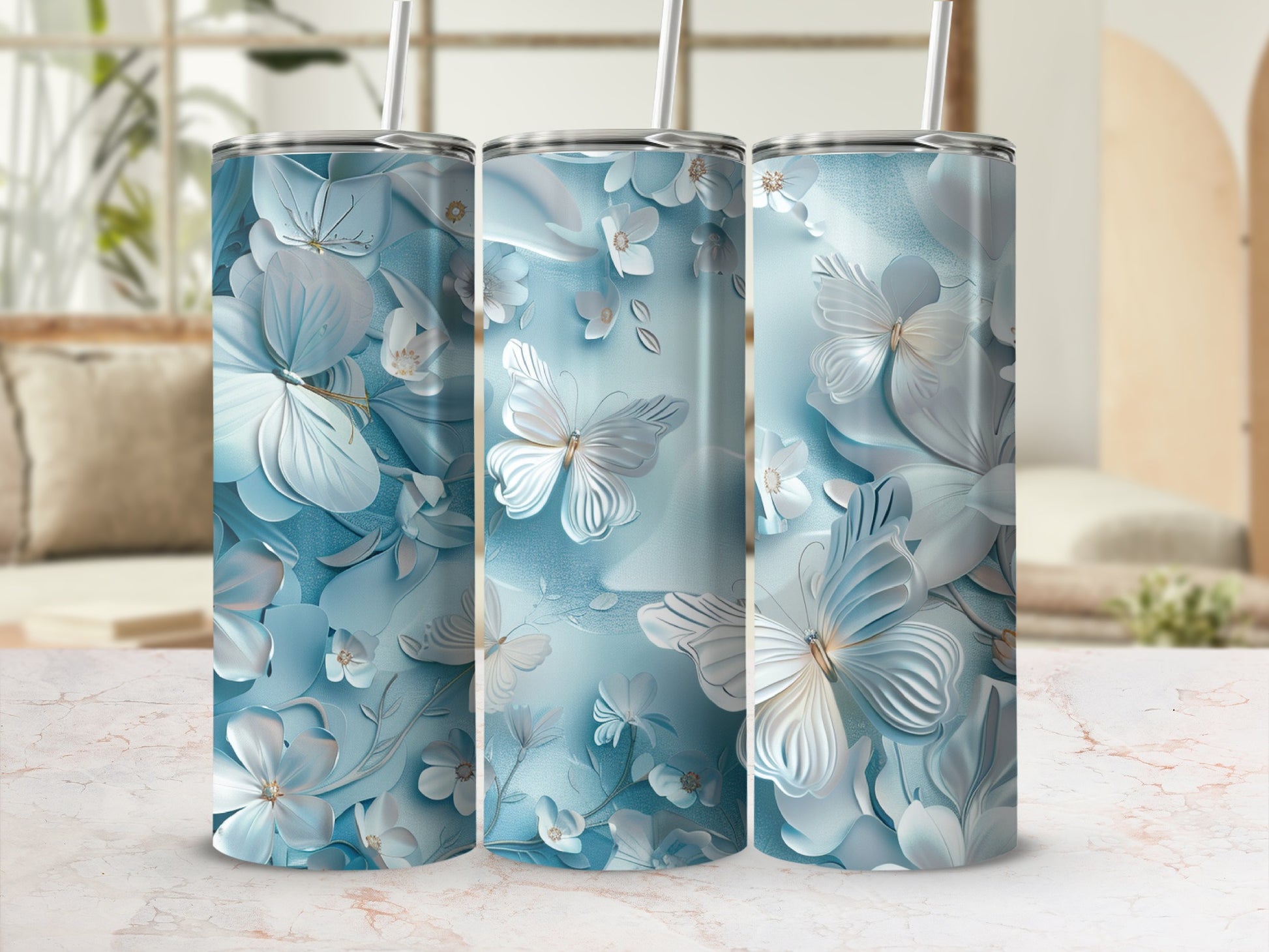 Three tumblers with a blue butterfly and floral design against a light background.